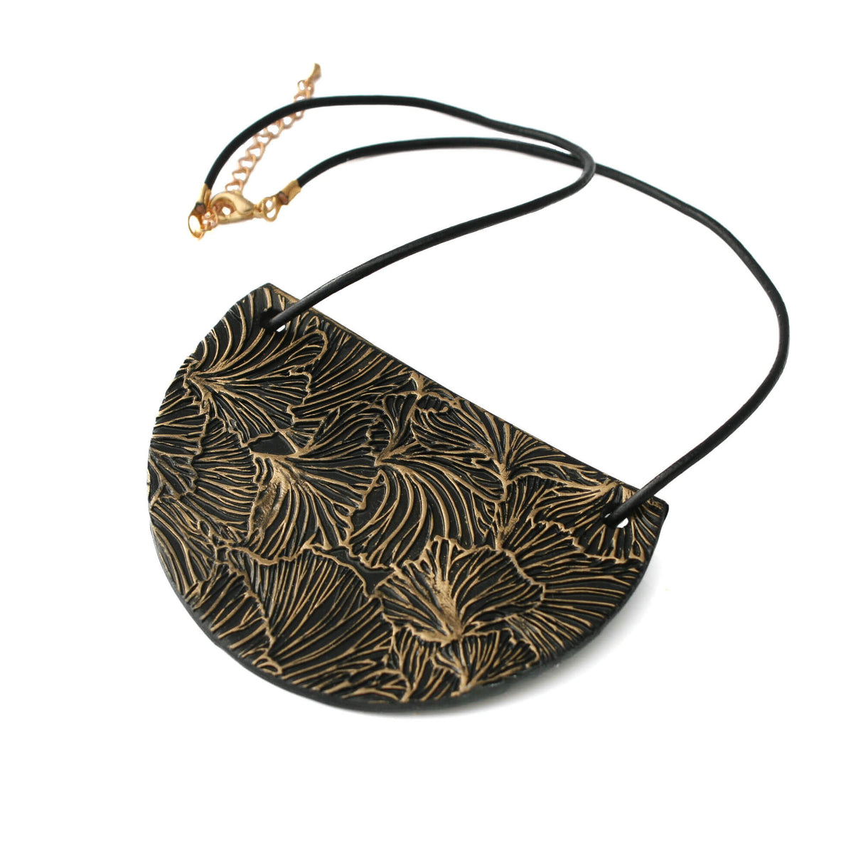 Black bib pendant necklace with gold ginkgo design