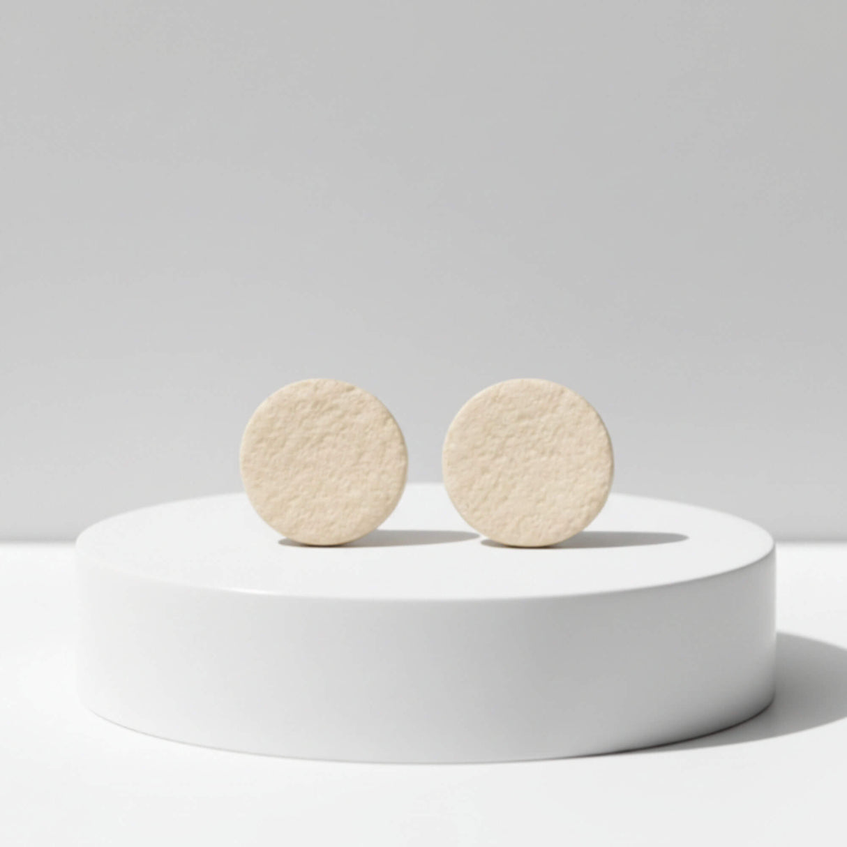 cream stud earrings on plinth, handmade clay jewellery at lottie of london 