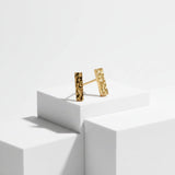 Gold bar stud earrings on plinth