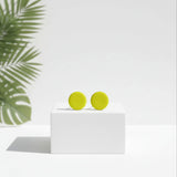 small lemon yellow stud earrings, handmade clay jewellery at lottie of london, lifestyle image on plinth