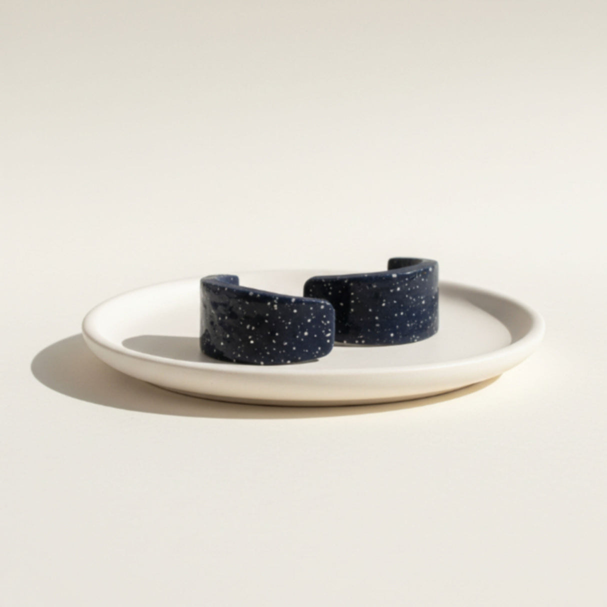 navy blue huggie hoop earrings, flat lay in dish, handmade at lottie of london