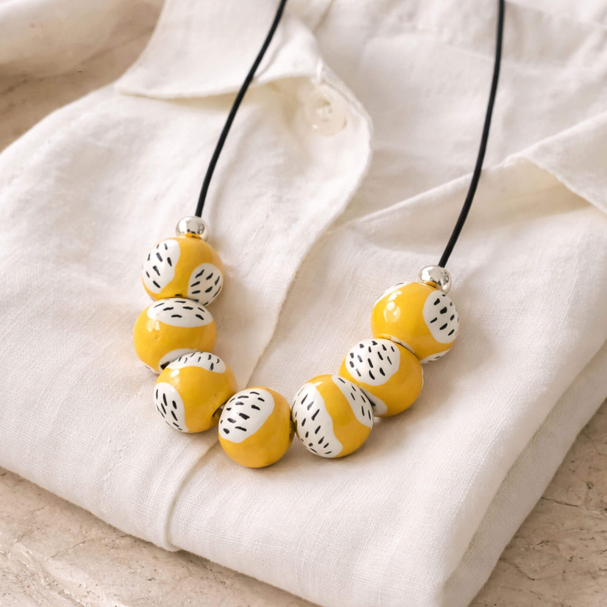 yellow bead necklace, handmade clay jewellery at lottie of london. flat lay image