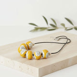 yellow statement bead necklace, handmade clay jewellery at lottie of london, flat lay image