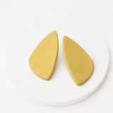 yellow geometric statement stud earrings on plinth