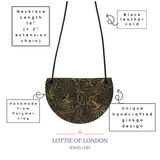 Black bib pendant necklace with gold ginkgo design
